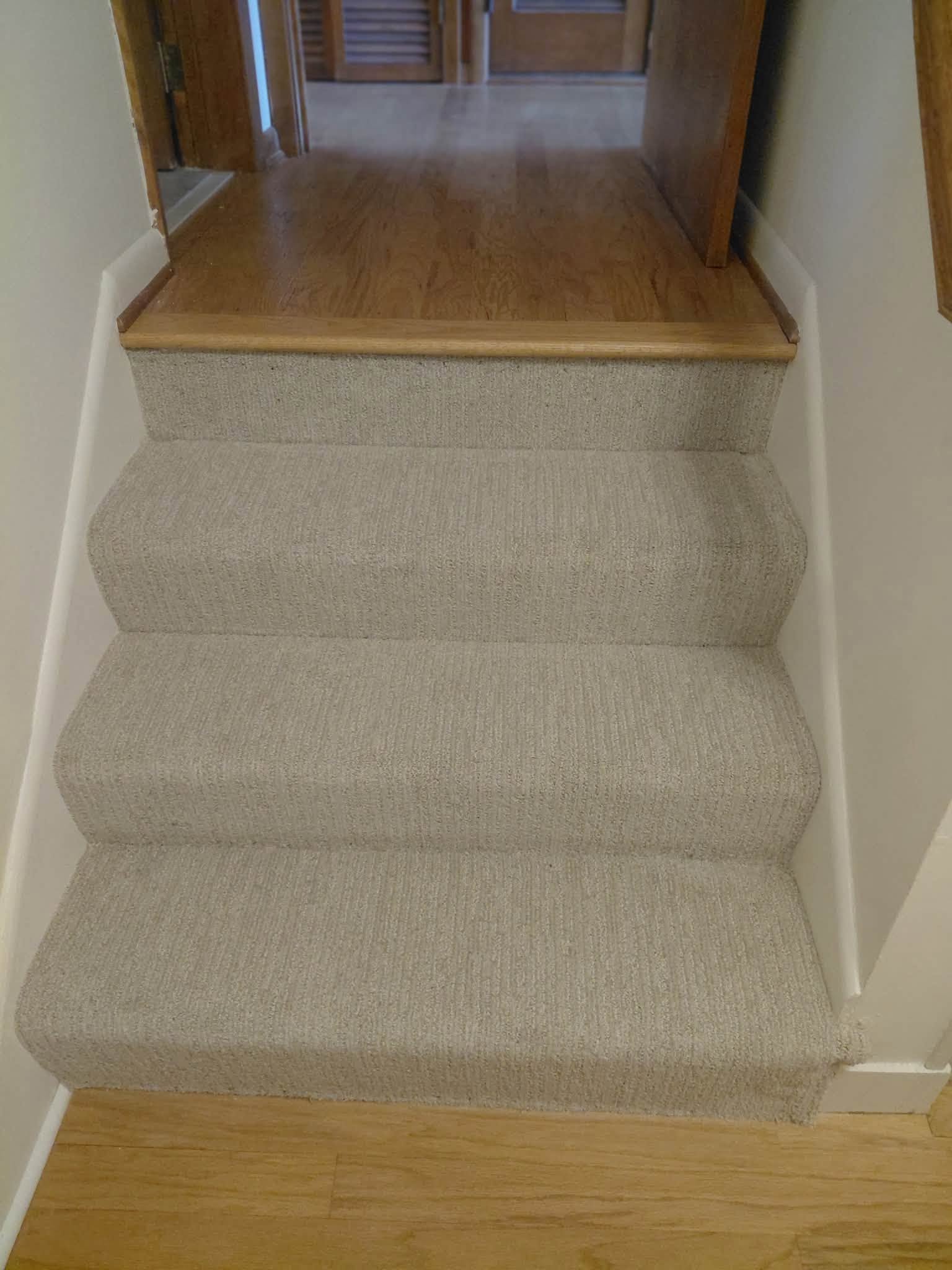 Carpeted stairs meeting a hardwood landing
