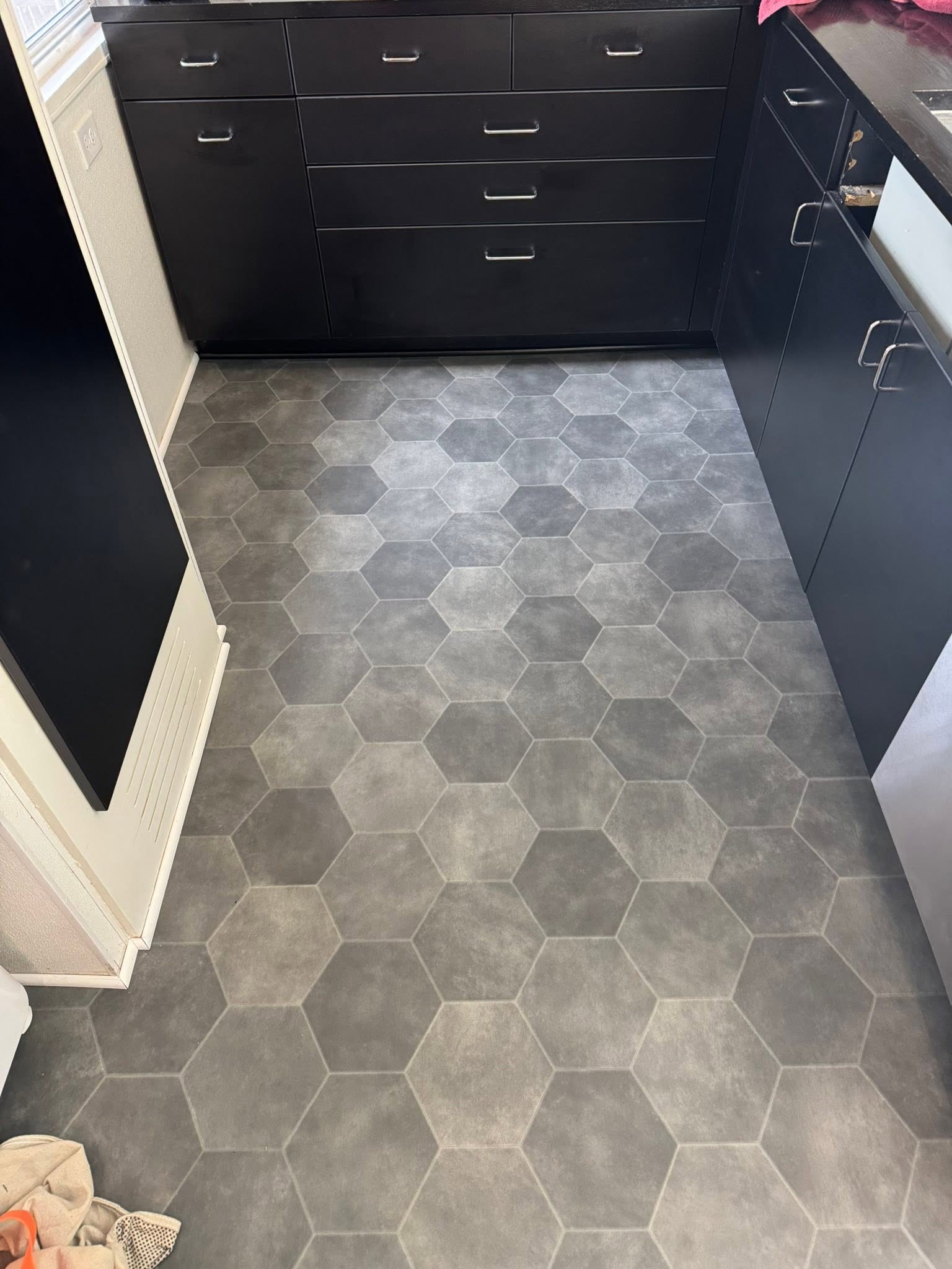 Gray hexagon tile-look flooring with black cabinetry